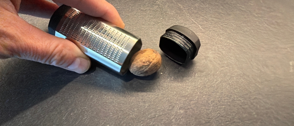 Eine Muskatnuss liegt neben der Wmf-Top-Tools-Muskatreibe