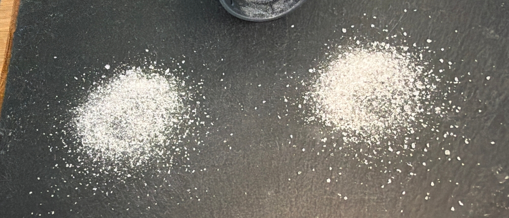 Gemahlenes Salz liegt neben einer Wmf-Trend-Gewürzmühle.