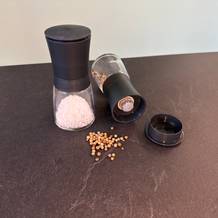 Pfefferkörner liegen neben den Wmf-Trend-Gewürzmühlen.