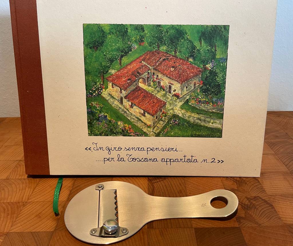 Trüffelhobel-Test: Ein Trüffelhobel liegt quer vor einem italienischen Buch.