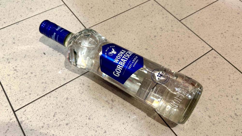 Auf einem Fließenboden liegt leicht horizontal eine Flasche des getesteten Wodka-Gorbatschows.