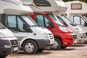 Wohnmobil mieten getestet: Verschiedene Wohnmobile stehen parkend in einer Reihe.