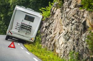 Wohnmobil mieten getestet: Vor einem verunglückten Wohnmobil steht ein Warndreieck.