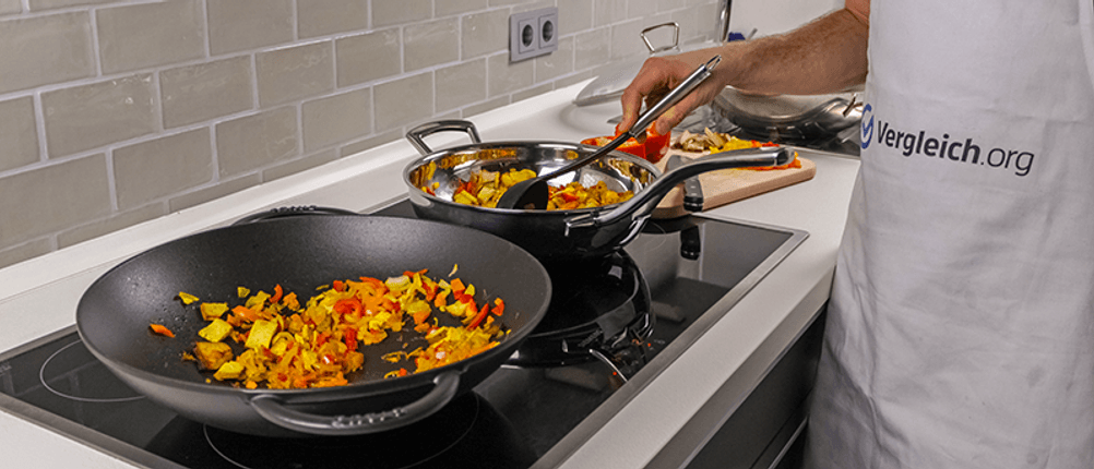 Verschiedene Woks stehen für einen Wokpfannen-Test auf dem Herd.