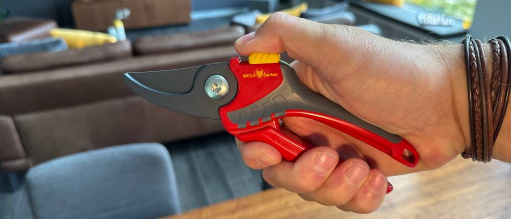 Eine Hand hält die Wolf-Gartenschere Comfort Plus fest