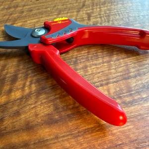 Die Wolf-Gartenschere Comfort Plus liegt geöffnet auf einem Tisch