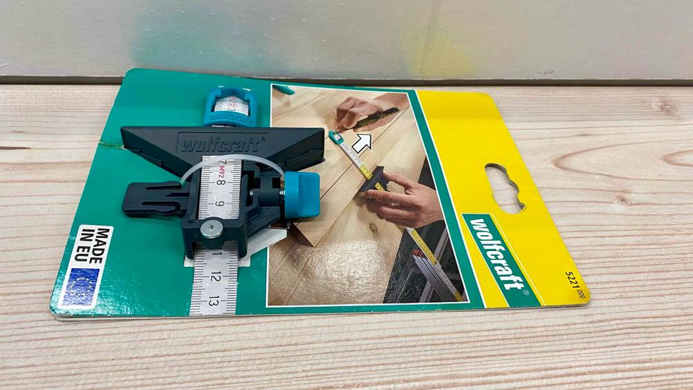 Im Test: Ein Streichmaß von schräg seitlich in seiner Originalverpackung auf einer Holzfläche.