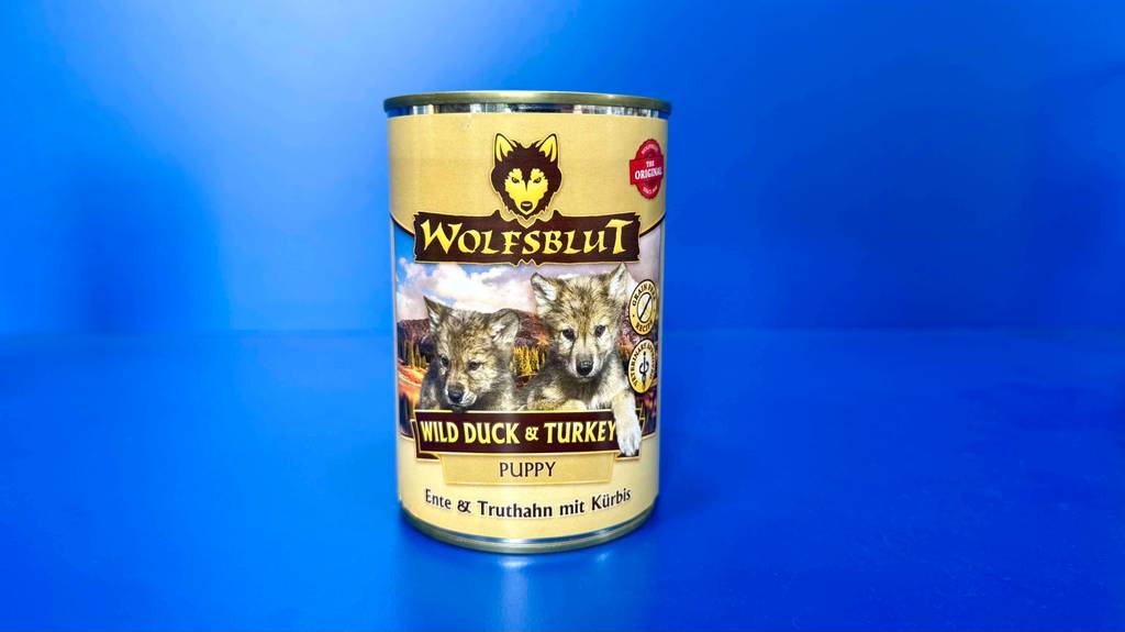 Eine Dose mit getestetem Wolfsblut-Welpenfutter steht vor einem blauen Hintergrund.