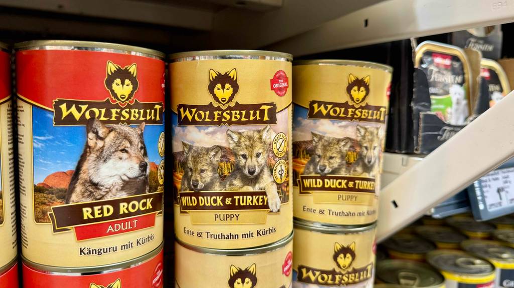 Wolfsblut-Welpenfutter im Test steht in Dosen neben weiteren Wolfsblut-Futtersorten auf einem Verkaufsregal.