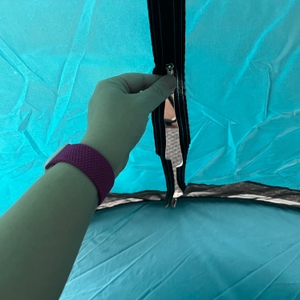 Eine Hand öffnet einen Reißverschluss der Wolfwise WF-INS-B-1