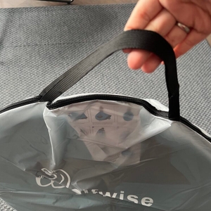 Eine Hand hält die Hülle der Wolfwise WF-INS-B-1 am Tragegriff