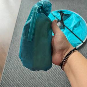 Eine Hand hält eine kleine türkise Tasche fest