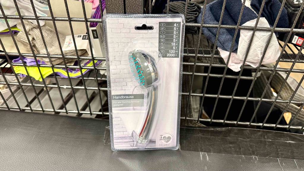 Getestet: Eine Handbrause in der Verpackung steht vor einem Verkaufskorb.
