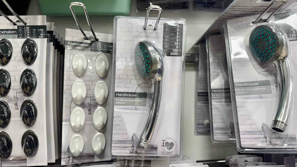 Getestete Handbrausen in der Verpackung hängen an einem Verkaufsstand.