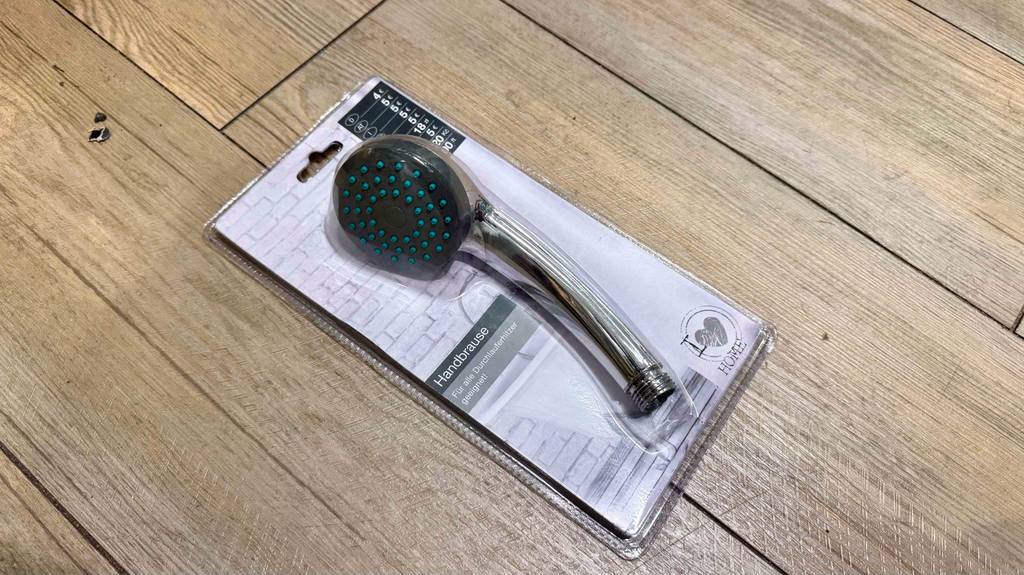 Eine getestete Handbrause in der Verpackung liegt auf dem Boden.