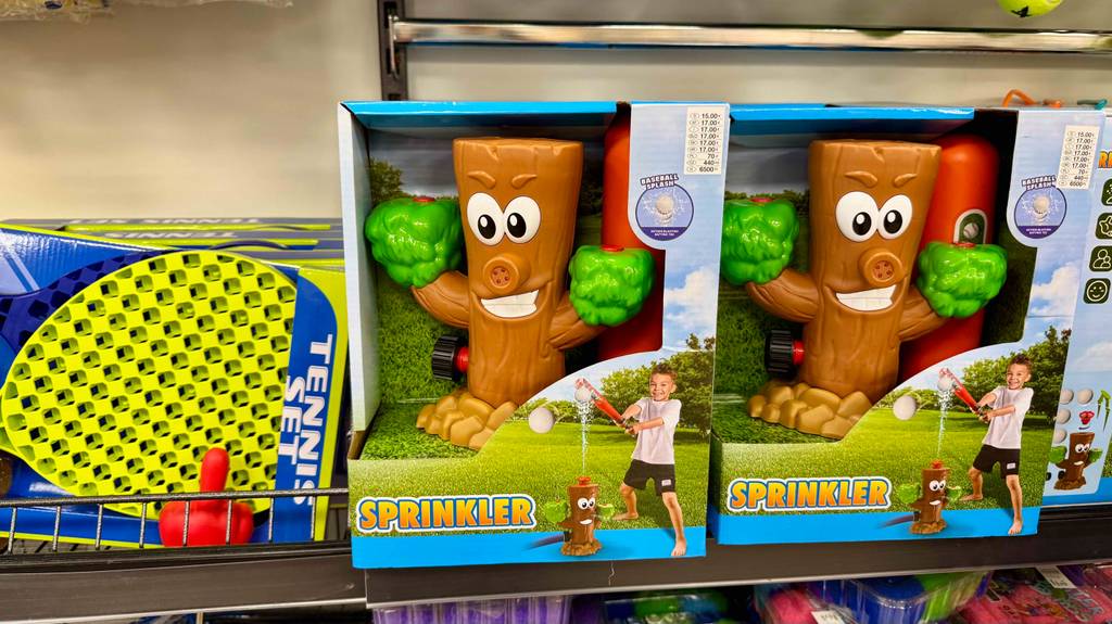 Im Test: Der Wassersprinkler für Kinder im Baumstamm-Design befindet sich innerhalb zweier Packungen auf einem Verkaufsregal.