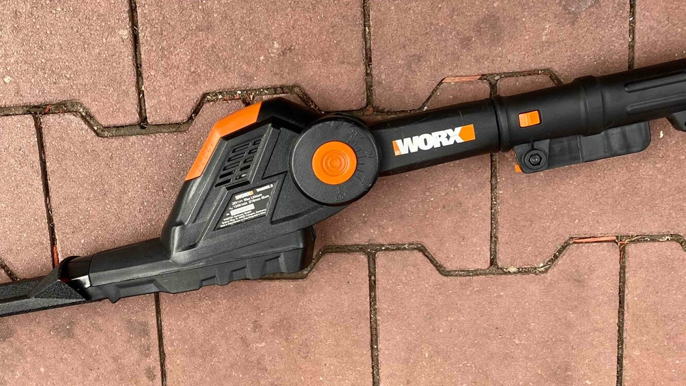 Nahaufnahme des Motors mit und des Gelenkes einer getesteten Akku-Teleskop-Heckenschere auf einem Pflasterstein.