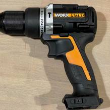 Der Worx Nitro WX352 Akkubohrer liegt auf einem Holzboden und ist von der Seite vollständig sichtbar. Das Werkzeug ist ohne Akku montiert und zeigt die Griff- und Gehäuseform.