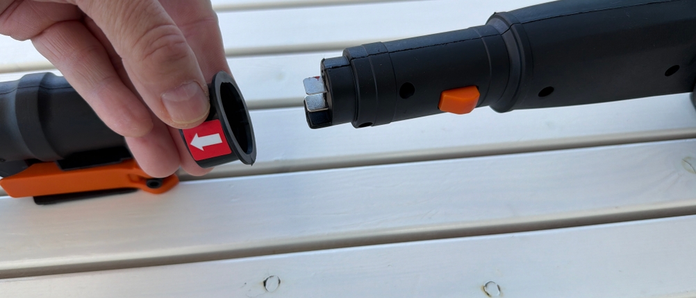 Eine Hand hat ein Plastikteil vom Stiel der Worx WG252E.9 gezogen.