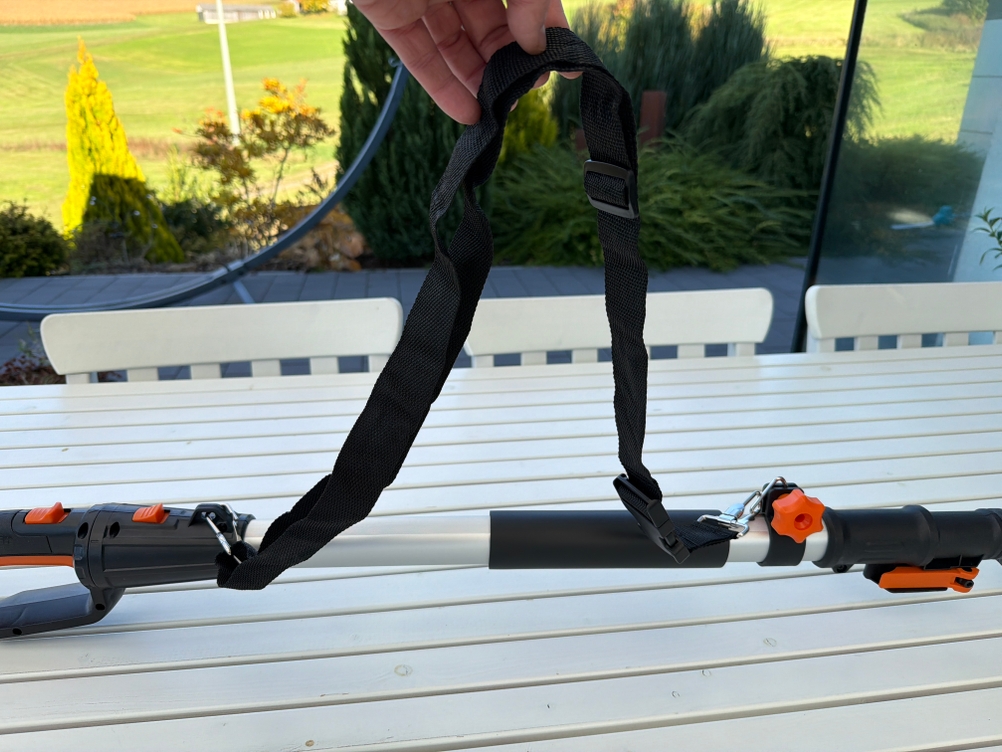 Eine Hand hält den Tragegriff der Worx WG252E.9 hoch.