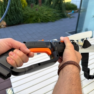 Eine Hand drückt auf die Sicherung der Worx WG252E.9.