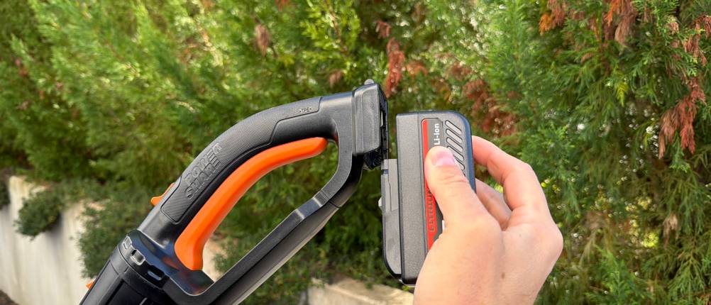 Eine Hand steckt den Akku an die Worx WG252E.9.