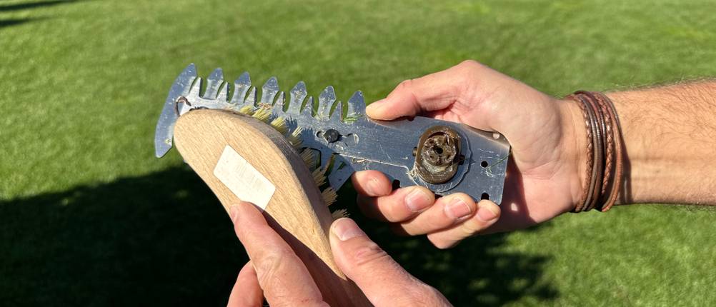 Mit einer Bürste wird das Messer der Worx WG801E.9 gereinigt.