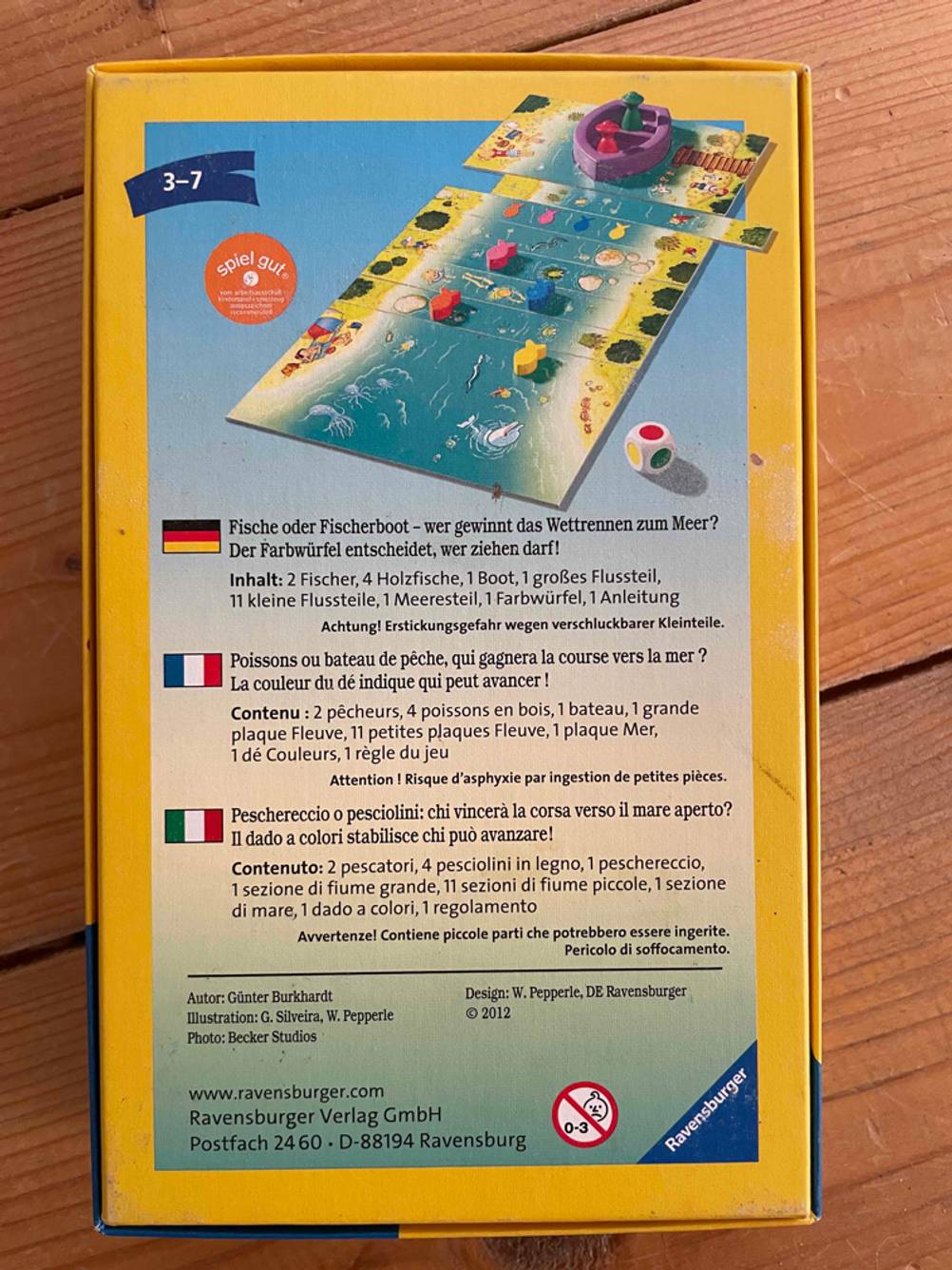Rückseite der Originalverpackung des getesteten Würfelspieles auf einer Holzfläche.