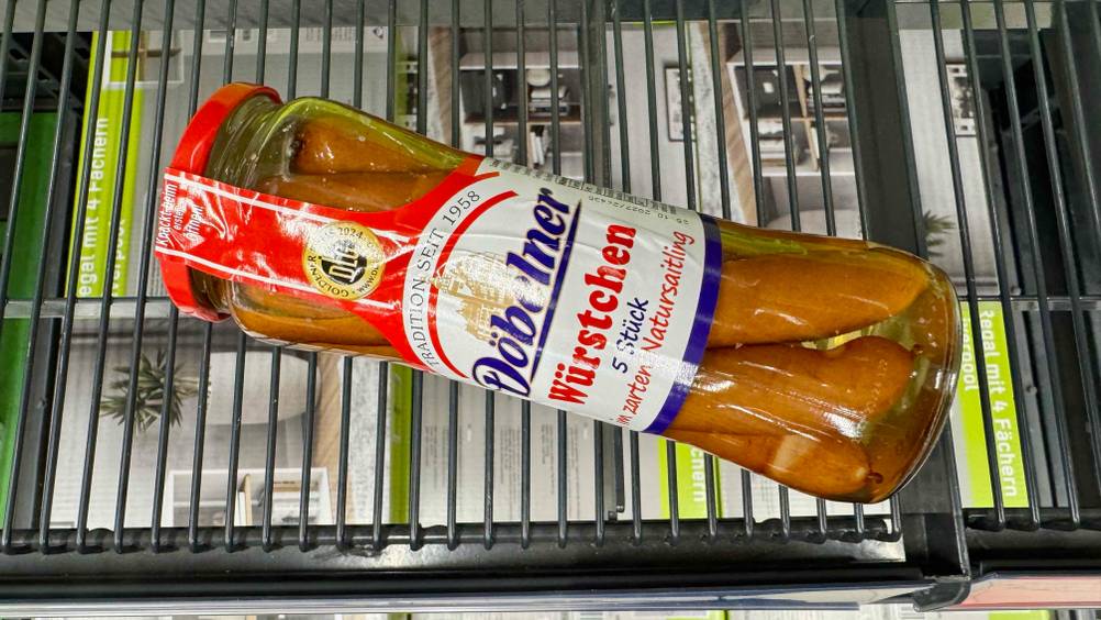Auf einem Gitter liegen Würstchen im Glas im Test.