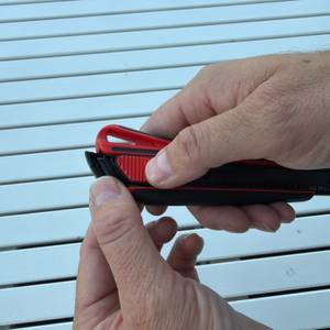 Eine Hand entfernt die Klinge aus dem Würth-2K-Cuttermesser