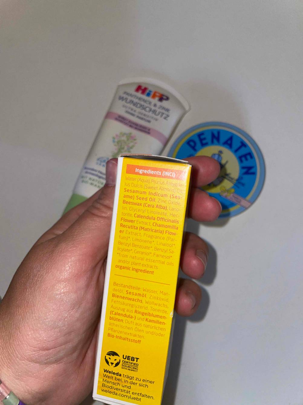 Seitenansicht einer Packung Wundschutzcreme im Test von einer Hand gehalten.