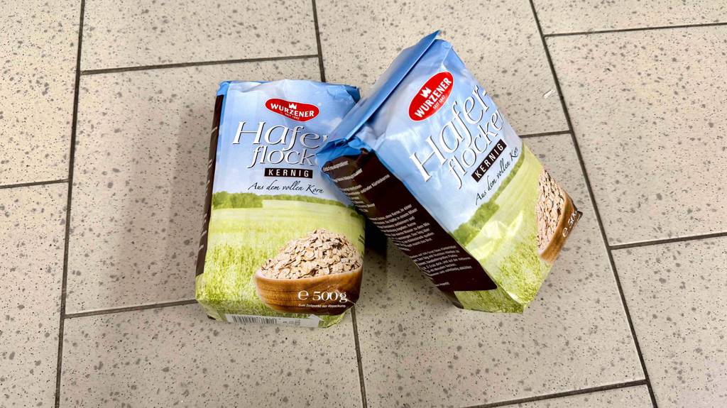 Getestet: Kernige Haferflocken in zwei 500-g-Packungen der Marke Wurzner befinden sich auf einem Fliesenboden.