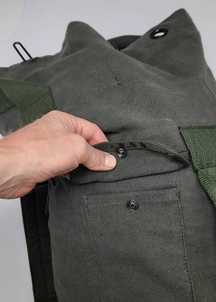 Seesack im Test: Eine Hand öffnet den Druckknopf der Verstautasche.