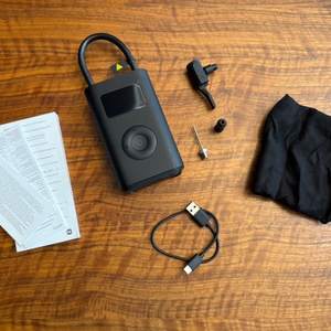 Der Lieferumfang vom Xiaomi Portable Electric Air Compressor 2 liegt auf einem Tisch