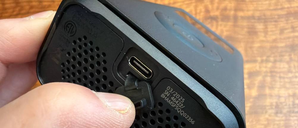 Eine Hand hält die Abdeckung vom Ladeanschluss vom Xiaomi Portable Electric Air Compressor 2