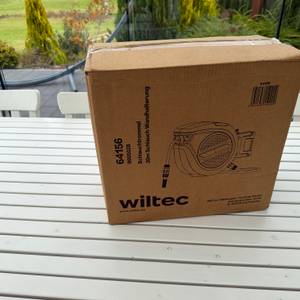 Der Karton der Xpotool-Schlauchtrommel steht auf einem Tisch