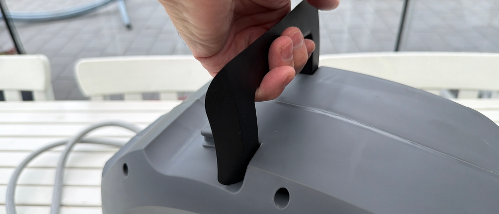 Eine Hand hält den Griff der Xpotool-Schlauchtrommel fest