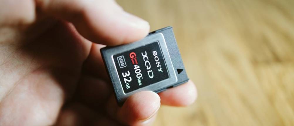 XQD-Speicherkarte-Test: Ein Mann hält eine 32-GB-XQD-Karte von Sony in der Hand.