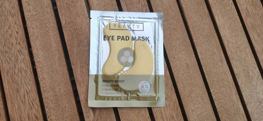 Augenpads-Test: eine versiegelte Verpackung inklusive zweier Augenpads liegt auf einer Holzoberfläche.