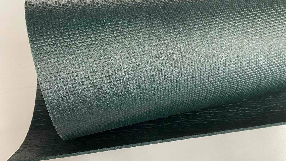 Nahaufnahme einer eingerollten Yogamatte im Test auf einer hellen Fläche.
