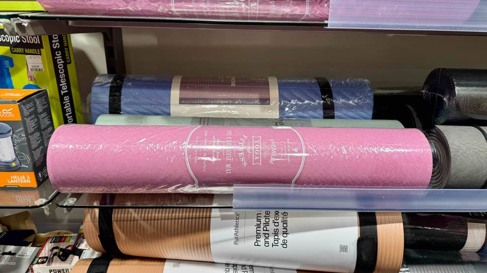 In einem Regal liegt die Yogamatte TPE im Test neben anderen Produkten.