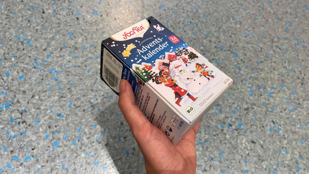 Hand hält eine Packung des getesteten Adventskalenders der Marke Yogi Tea hoch.