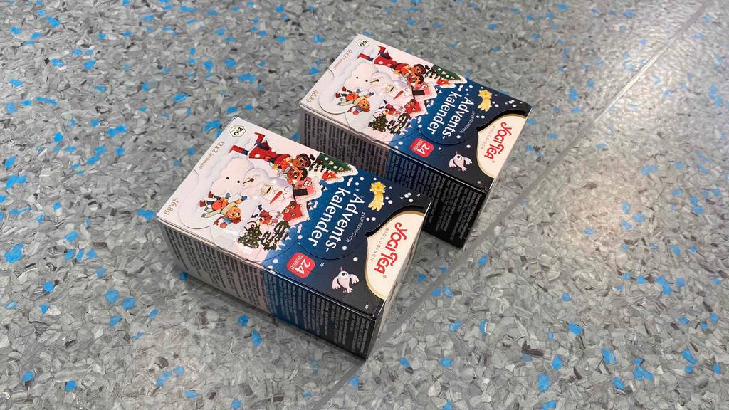 Auf einem gesprenkelten Untergrund befinden sich zwei geschlossene Adventskalender von Yogi Tea mit jeweils 24 Teebeuteln
