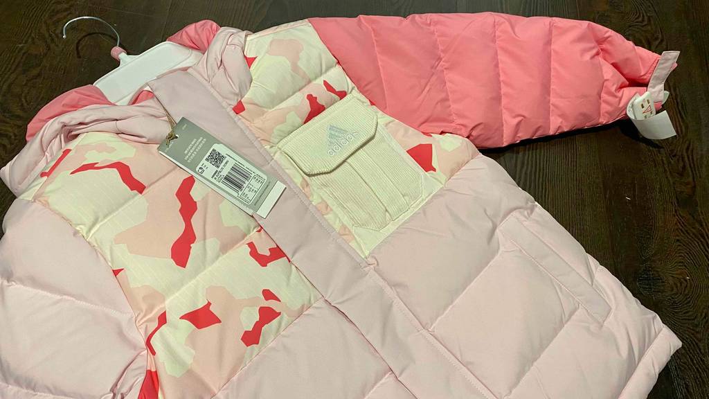 Blick auf die mit Druckknopf verschlossene Brusttasche einer Kinderwinterjacke für Mädchen im Test.