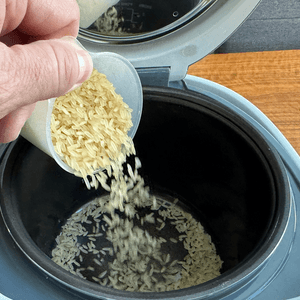 Aus einem Behälter wird roher Reis in den Yum Asia Panda gefüllt