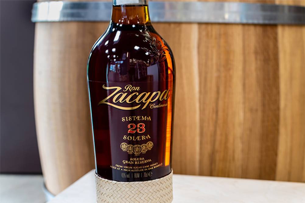 Zacapa-Rum im Test: Hier eine Zacapa-23-Flasche vor einem Fass. 
