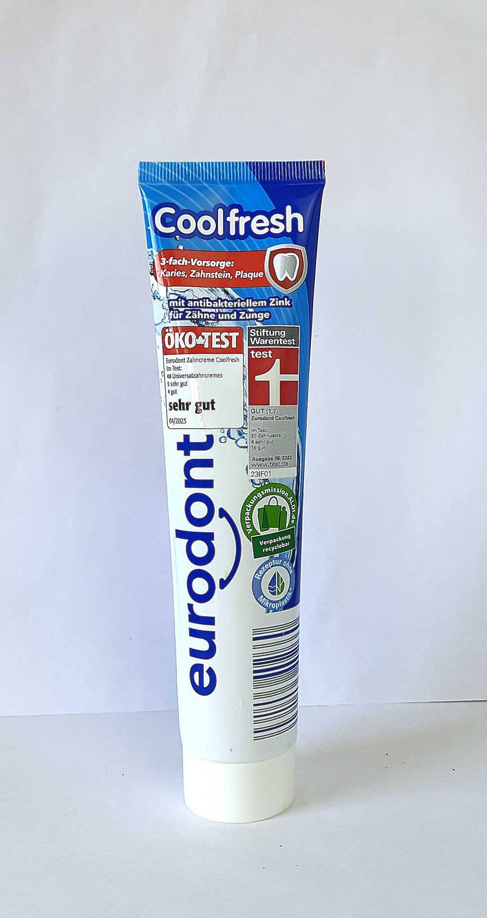 Eine Tube Zahnpasta ohne Mikroplastik im Test von vorne vor einer hellen Wand.