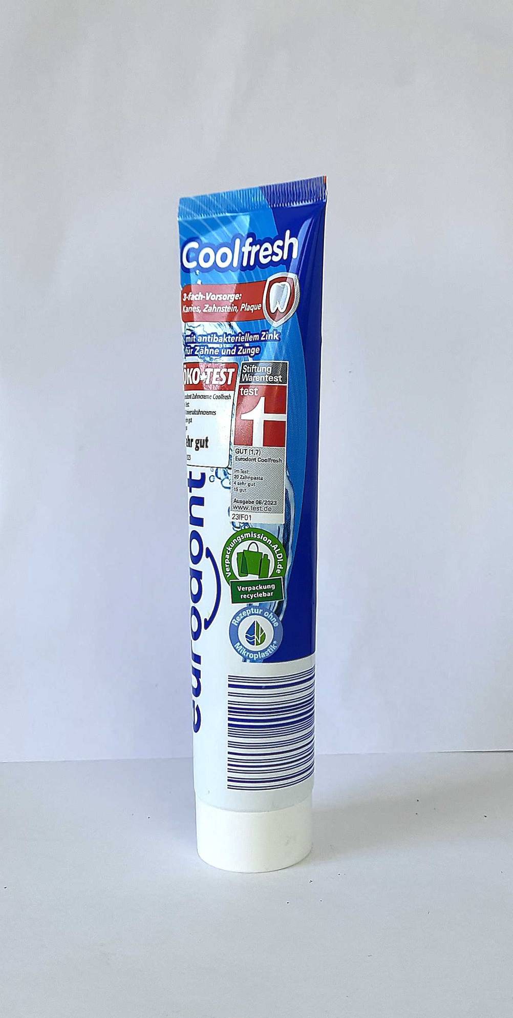 Eine Tube Zahnpasta ohne Mikroplastik im Test vor einer hellen Wand.