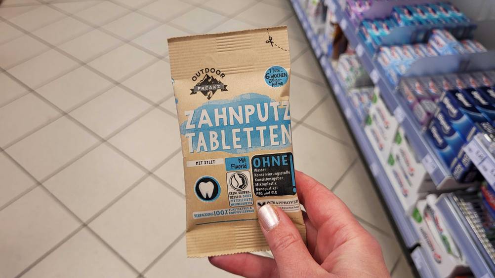 Eine Hand hält eine Packung der Zahnputztabletten im Test.