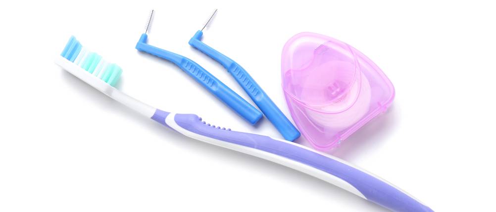 Zahnreinigungsset-Test: Eine Zahnbürste, eine Zahnseide und zwei Interdentalbürsten sind vor einem weißen Hintergrund ersichtlich.